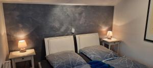 two beds in a room with two lamps on the wall at Ferienwohnung Wildgatter in Grafenwiesen