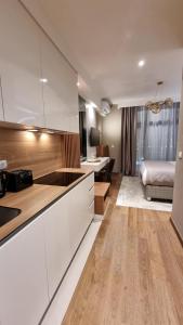 - une cuisine avec des placards blancs et un lit dans une chambre dans l'établissement Belgrade Waterfront-Beograd na vodi - BW Arcadia Lux, à Belgrade