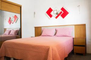 um quarto com uma cama com lençóis cor-de-rosa e um espelho em Casa perto da Praia Canto da Barra em Fortim CE em Fortim