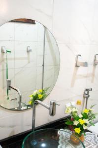 a bathroom sink with a round mirror above it at Casa perto da Praia Canto da Barra em Fortim CE in Fortim