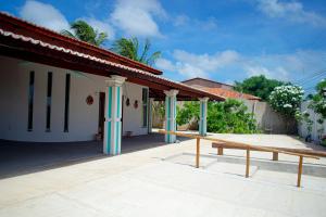 a bench in front of a building with blue columns at Casa perto da Praia Canto da Barra em Fortim CE in Fortim
