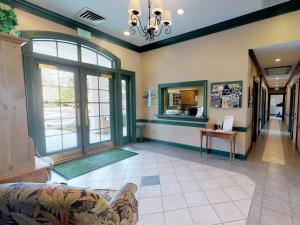 a living room with a couch and a large window at Owners Club At Hilton Head - Managed by Elite Alliance in Hilton Head Island