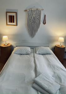 1 cama con 2 almohadas y 2 lámparas en un dormitorio en Gościniec Odsapka, en Murzasichle