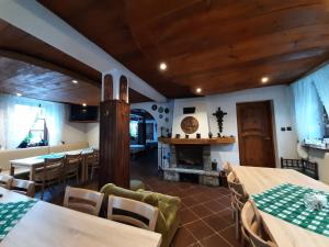 a dining room with tables and chairs and a fireplace at Willa Krokus in Miedzygorze