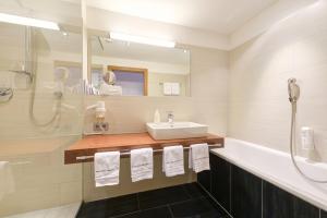 a bathroom with a sink and a shower at Hotel Alpenland in Sankt Anton am Arlberg +19 photos