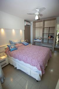 a bedroom with a large bed and a ceiling fan at Apartamento com Wi-Fi no centro de Guarapari ES in Guarapari