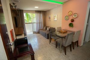 a living room with a table and a dining room at Apartamento com Wi-Fi no centro de Guarapari ES in Guarapari