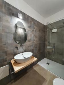 La salle de bains est pourvue d'un lavabo blanc et d'une douche. dans l'établissement Blue Velvet Rooms, à Tortolì