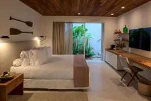a bedroom with a bed and a desk and a television at Hotel Fasano Trancoso in Trancoso +24 photos