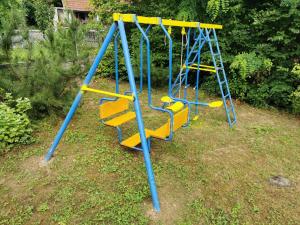 a blue and yellow swing set in a yard at Jumiko Apartments in Vrnjačka Banja