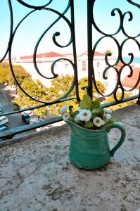 a green vase with flowers in it next to a window at Alfama District by be@home in Lisbon