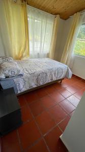 een slaapkamer met een bed en een raam bij Cabaña Mi Terruño in Cogua