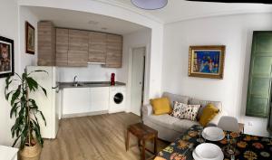 a living room with a couch and a kitchen at Afiador in Ourense