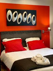 Schlafzimmer mit roten Wänden und einem Bett mit roten Kissen in der Unterkunft Bethune City Relax Spa & Sauna in Béthune