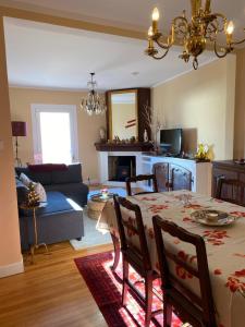 a dining room and living room with a table and a couch at Chez Hélène 3 étoiles, labellisé disabled PMR,pour 4 personnes chiens bienvenus-pet friendly in Bourg-Madame