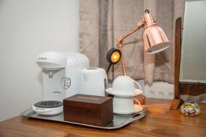 a table with a coffee maker and a lamp on it at Stay@27 in Brighton & Hove