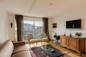 een woonkamer met een bank en een flatscreen-tv bij Le Kaliste - apartment for 4 people garage in Annecy