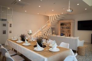 a dining room with a long table and white chairs at Casa Rural Vamos Allá in Campo de Criptana