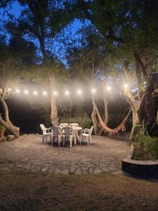 un patio con mesas blancas y sillas por la noche en Los Oleandros - casa privada en Nono