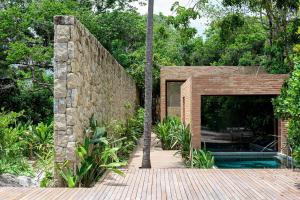 una casa con una pared de piedra y una piscina en Hotel Fasano Trancoso, en Trancoso