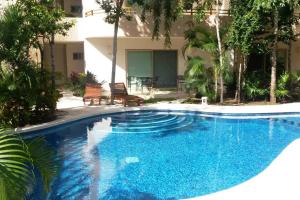 a swimming pool in front of a house at Beautiful condo with pool in Tulum