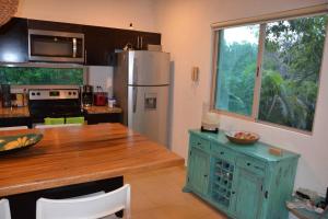 a kitchen with a refrigerator and a wooden counter top at Beautiful condo with pool in Tulum