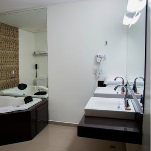 a bathroom with three sinks and a mirror at Golden Plaza Hotel in Porto Velho