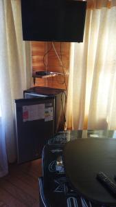 a desk with a computer and a table with a lamp at Cabañas MI REFUGIO in Isla Negra