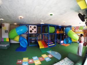ナタールにあるVila do Mar by GoldMen Hospitalityの遊び場のあるプレイルームに立っている女性
