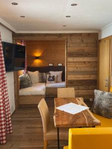 a living room with a table and a bedroom at Apart Ursus Hinterthal in Maria Alm am Steinernen Meer