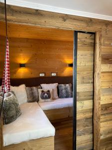 a room with a couch in a wooden wall at Apart Ursus Hinterthal in Maria Alm am Steinernen Meer
