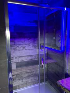 La salle de bains est pourvue d'une douche avec une lumière bleue. dans l'établissement BREEZE SUITES - LUXURY GROUP ACCOM - SLEEPS 19, à Blackpool