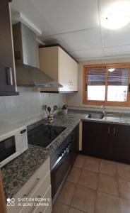 eine Küche mit Spüle und Herd oberen Backofen in der Unterkunft LOFT ALQUILER ALCALALÍ in Alcalalí