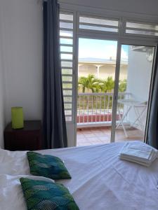 1 dormitorio con 1 cama y vistas a un balcón en Les plages de Macabou, en Le Vauclin