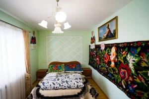 a bedroom with a bed with a painting on the wall at Casa Giorgiana in Statiunea Borsa