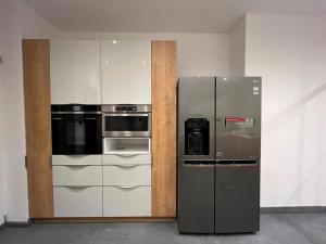 Il comprend une cuisine équipée d'un réfrigérateur et d'appareils en acier inoxydable. dans l'établissement Designer Apartment 110m2 with King Size Beds & Equipped Kitchen, à Cracovie