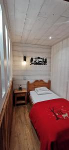 a bedroom with a bed with a red blanket at Le Renne Blanc Pyrénées de France in Font-Romeu