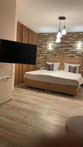 um quarto com uma cama e uma parede de pedra em Вила Релакс em Smolyan