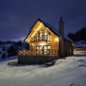 a log cabin in the snow at night at Idila Zaovinskog jezera in Zaovine