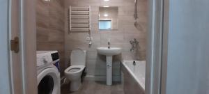 ein Badezimmer mit Toilette, Waschbecken und Waschmaschine in der Unterkunft New clean apartments in Winnyzja + 17 Fotos