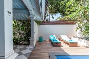 a patio with two benches and a pool at Villa Seni in Seminyak