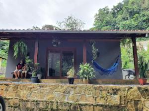 een vrouw die op de veranda van een huis zit bij Loft Pé na Serra in Cachoeiras de Macacu