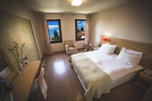 ein Schlafzimmer mit einem großen Bett und zwei Fenstern in der Unterkunft Portaria Hotel in Portaria