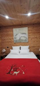 um quarto com uma cama com um cobertor vermelho em Le Renne Blanc Pyrénées de France em Font-Romeu
