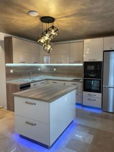 uma grande cozinha com armários brancos e um lustre em Вила Релакс em Smolyan