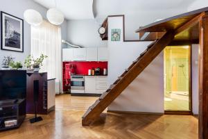 a kitchen with a wooden staircase in a living room at Stylish Studio Kronstadt in Braşov