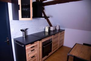 kuchnia z czarnym blatem i kuchenką w obiekcie L'Atelier Brainois - Meublé de tourisme 3*** w mieście Braine