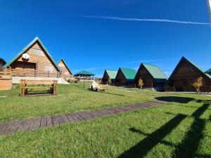 una fila de cabañas de madera con techos verdes en Woodland, en Žabljak