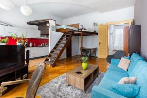 sala de estar con sofá azul y loft en Stylish Studio Kronstadt, en Brasov