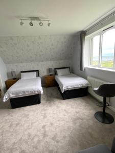 a bedroom with two beds and a window at Aultnagar Accommodation in Orkney